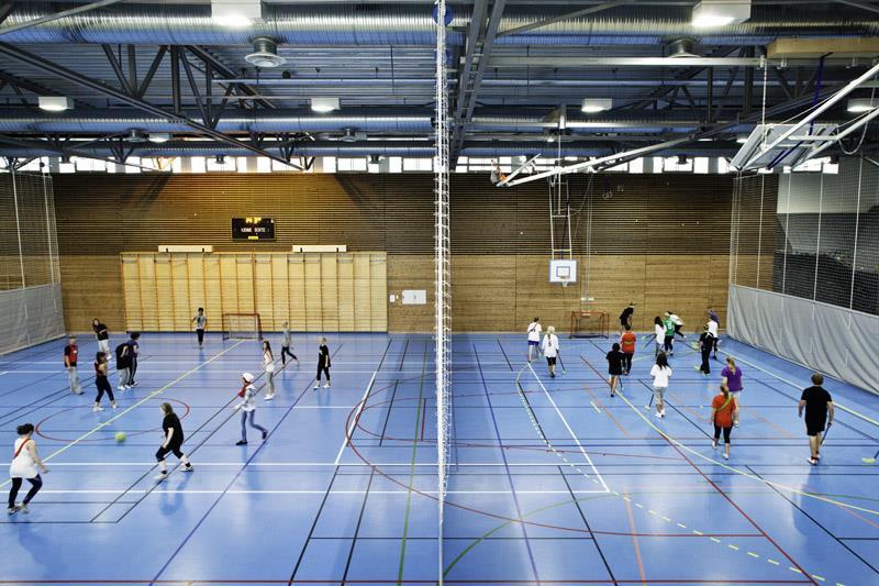 Idrettshall med ungdommer som har ballspill - Klikk for stort bilde